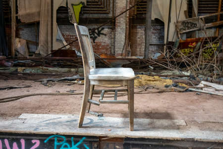 An Old and Broken Wooden Chair on the Stage of an Abandoned Theatreの写真素材