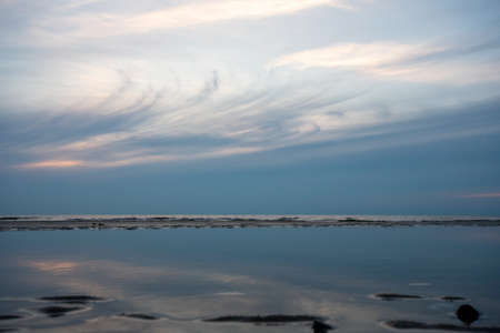 An Abstract Shot of A Whispy Sunset Sky Mirrored in a Pool of Waterの写真素材