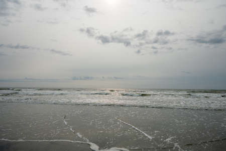 A View of the Horizon OVer the Ocean on a Beach on a Cloudy Grey Skyの写真素材