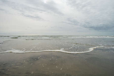 A View of the Horizon Over the Ocean on the Beach on a Cloudy Grey Skyの写真素材