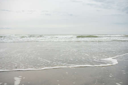 A View of the Horizon Over the Ocean on the Beach on a Cloudy Grey Skyの写真素材