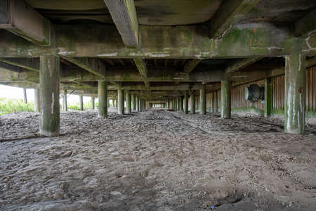 Looking Down at the Underside of a Boardwalk With Sand Underneathの写真素材
