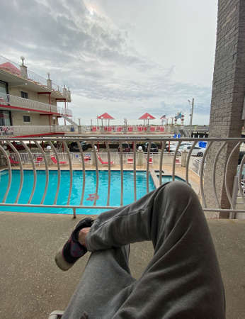 The Crossed Legs of a Man Relaxing at an Oceanfront Resortの写真素材