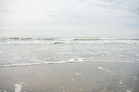 A View of the Horizon Over the Ocean on the Beach on a Cloudy Grey Skyの写真素材
