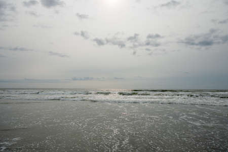 A View of the Horizon OVer the Ocean on a Beach on a Cloudy Grey Skyの写真素材