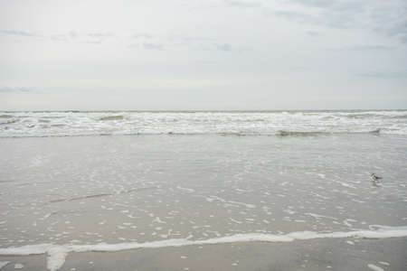 A View of the Horizon Over the Ocean on the Beach on a Cloudy Grey Skyの写真素材