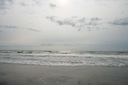 A View of the Horizon OVer the Ocean on a Beach on a Cloudy Grey Skyの写真素材