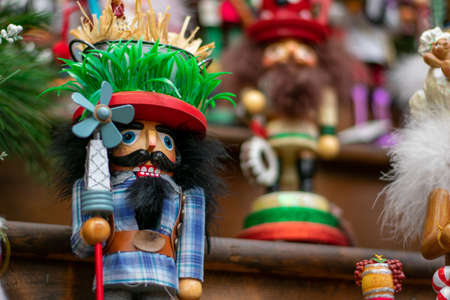 A Funny Looking Nutcracker on a Wooden Shelf In Line With Other Nutcrackersの写真素材