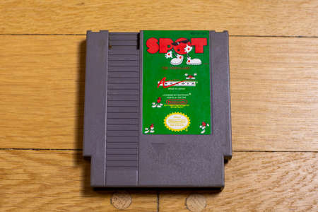 A Spot Cartridge for the Nintendo Entertainment System on a wood floor.のeditorial素材
