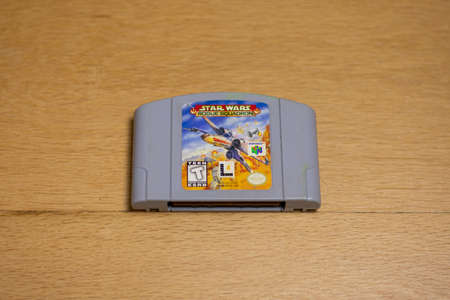 A Cartridge of Star Wars Rogue Squadron for the Nintendo 64 on a wood floor.のeditorial素材