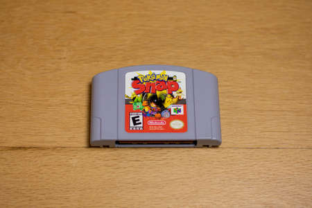 A Cartridge of Pokemon Snap for the Nintendo 64 on a wood floor.のeditorial素材