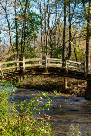 A Wooden Bridge Going Over a Small Stream on a Clear Autumn Day at Valley Forge National Historical Parkの写真素材