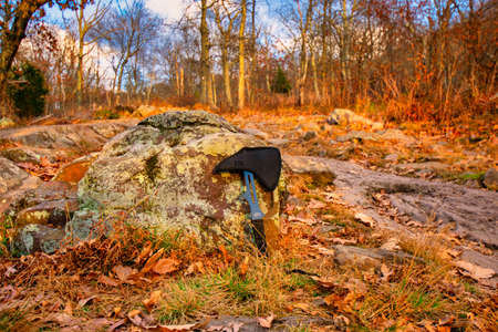 A Small Throwing Axe Leaning on a Rock in an Autumn Fieldの写真素材
