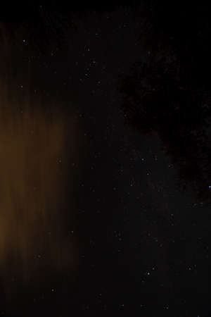 A Dark Night sky Full of Stars and Orange Clouds During Autumnの写真素材