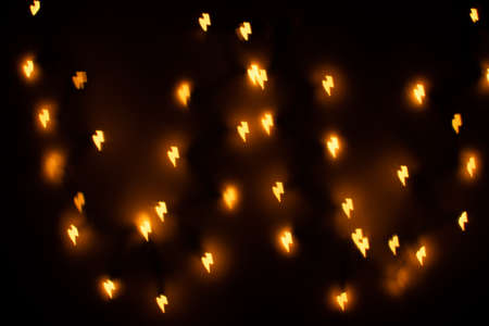 Yellow Lightning Bolt Shaped Bokeh on a Black Backgroundの写真素材