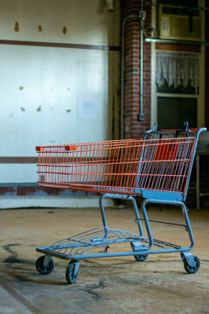 A Red Shopping Cart In a Large Empty Room in a destroyed Abandoned Buildingの写真素材