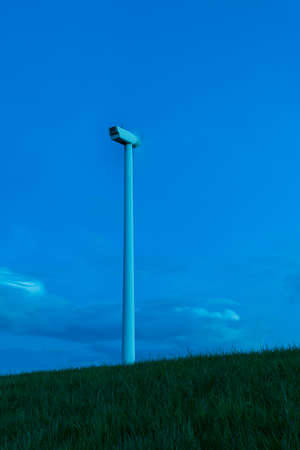 Wind power plant on green lawn. Photo at sunset long time. There are nice blue clouds in the sky.の写真素材