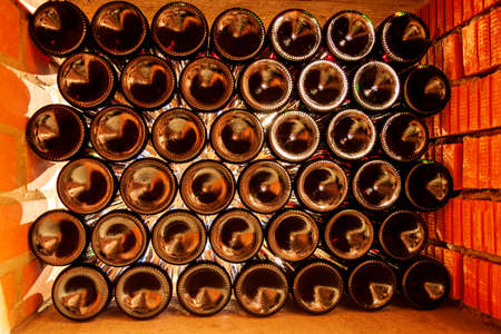 Bottles of wine lying horizontally in a niche. The bottom of the bottle is visible, through which...