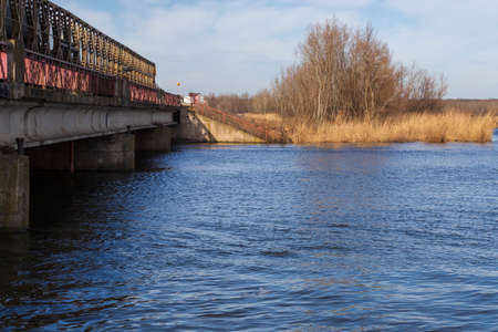 Iron bridge over the Nove Mlyny reservoir in the Czech Republic. On background are trees and blue sky with white clouds.の写真素材