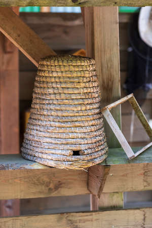 Demonstration of a wicker hive for bees. There is a plastic next to the hive.の写真素材