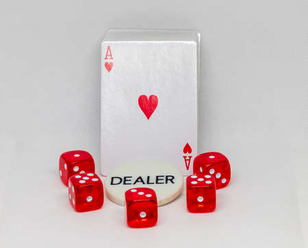 Red dice for casino on a white background with a plaque with the inscription dealer. A deck of cards...