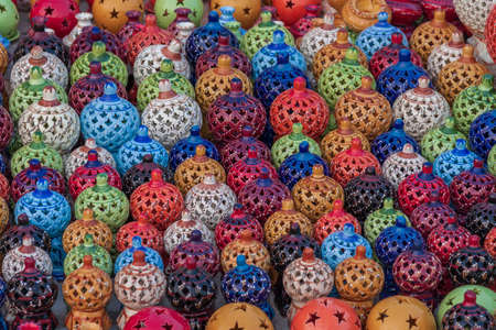 Beautiful colorful traditional ceramic items - plates and lamps at a market in Tunisia.