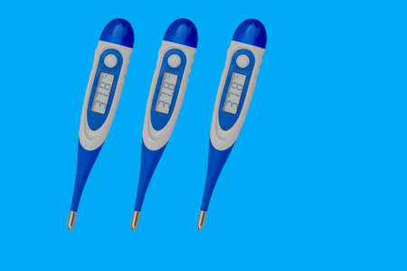 Three blue-white digital thermometer for measuring body temperature. The thermometer is isolated on...