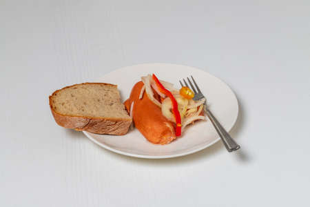 Sausage - marinated in sour pickle with vegetables served with bread. Drowned - Czech specialty. The food is on a white plate on a white table.の写真素材