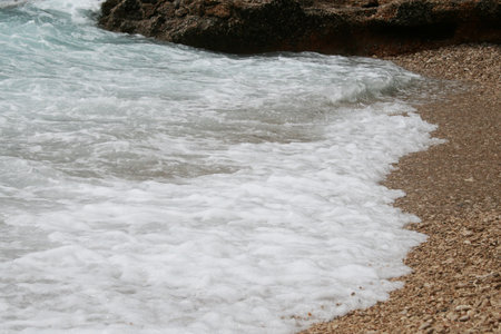 The sea wave hits the shore and rocks on the shore.の写真素材
