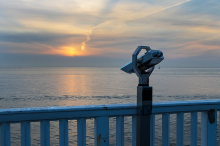 Lookout point with binoculars and view of North Sea in Cuxhaven town in Germany. In the background...
