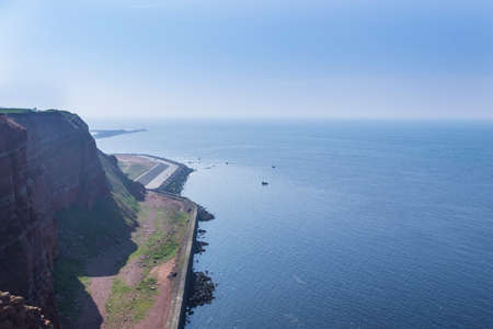 Beautiful rocky coastline with sea and blue sky Long Anna on Helgoland island in Germany.の写真素材