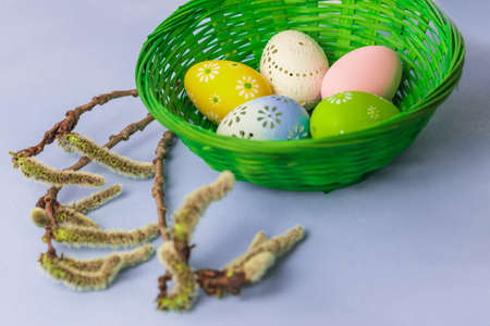 Easter egg as a decoration in a green basket. Decorated Easter eggs on the Easter table. The...