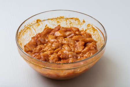 Raw chicken breasts are cut into small pieces. Pickled and seasoned with spices, placed in a glass...