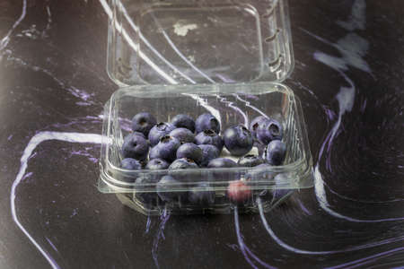 Blue-purple blueberries on a black-white background. Blueberry still life.