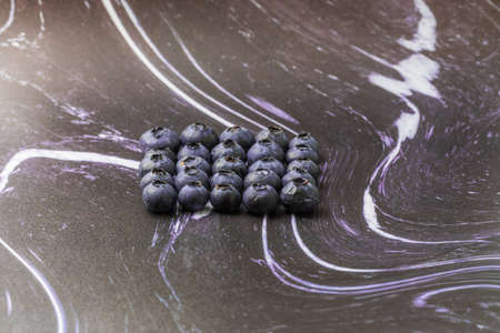 Blue-purple blueberries on a black-white background. Blueberry still life.