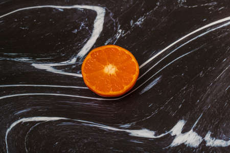 Tangerine wheels on a dark background. The background is black and white.の写真素材