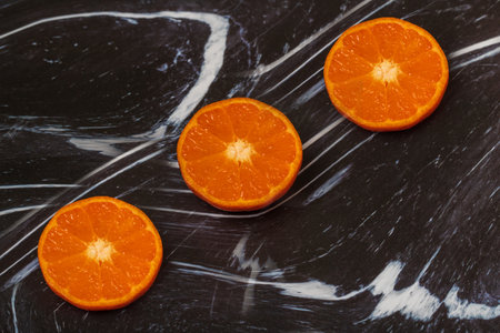 Tangerine wheels on a dark background. The background is black and white.の写真素材