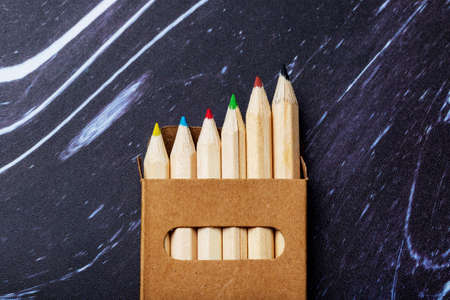 Wooden colored crayons on a dark background.の写真素材