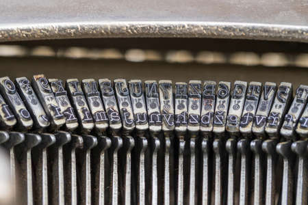 Old typewriter punch letters and numbers. There is dirt on the letters.