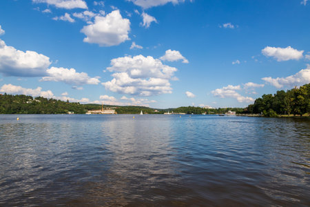 Brno Dam Czech Republic Europe. Water surface and dam. In the background is the housing estate Bystrc and Kohoutovice. The sky is blue with white cloudsの写真素材