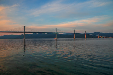 Beautiful modern bridge over the sea on Peljesac in Croatia. In the foreground houses and in the...