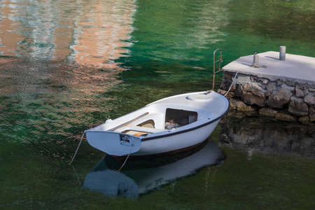 A small beach in a bay by the sea. There are water toys and beach chairs on the beach.の写真素材