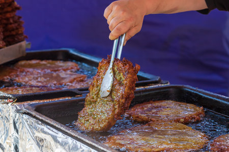 Street food cooked in a pan at the market. Baked potatoes until golden brown. Food specialties.