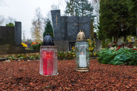 Burning candles in the cemetery in remembrance of the memory of the deceased. Grave decoration.