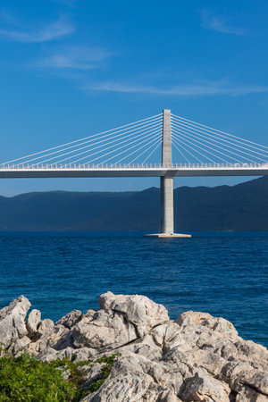 Beautiful modern bridge over the sea to the island of Peljesac in Croatia - Europe. Against the background of mountain ranges and a nice sky with clouds.の写真素材
