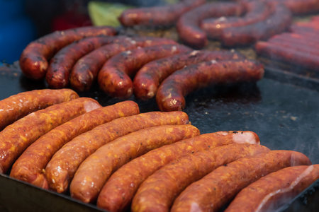 Street food in a large pan and grill at the market. The man is smoking.