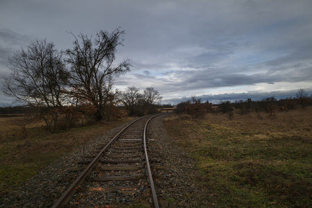 A landscape traversed by a monorail. There are heavy dark clouds in the sky.