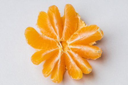 Tangerine in a split peel on a white table.
