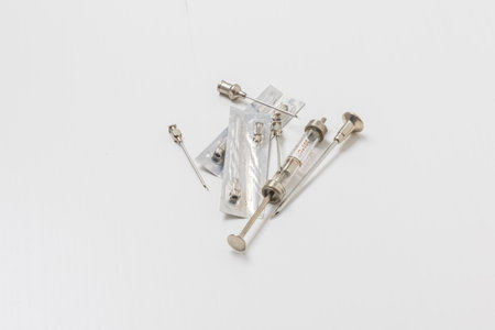 Syringe, needles and test tube on a white background.