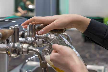 Hands pouring beer into a glassの写真素材